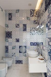 a bathroom with blue and white tiles on the wall at Relais Mareluna - Luxury Apartments in Salerno