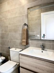 een badkamer met een wastafel, een toilet en een spiegel bij Apartamento de la Candelaria I in Santa Cruz de Tenerife