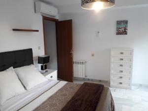 een slaapkamer met een bed en een dressoir bij Apartamentos Sol Real 1 in Úbeda