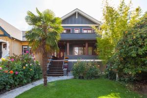 a house with a palm tree in the yard at Beautiful, Quiet 3BR in Posh Kitsilano in Vancouver