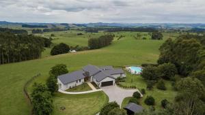 an aerial view of a house in a green field at The Rise in Waimate North