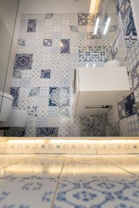 a bathroom with a sink and blue and white tiles at Relais Mareluna - Luxury Apartments in Salerno