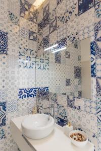 a blue and white bathroom with a sink and a mirror at Relais Mareluna - Luxury Apartments in Salerno