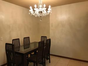 comedor con mesa, sillas y lámpara de araña en IMACULADO APARTAMENTO A 20 METROS DA PRAIA, en Balneário Camboriú