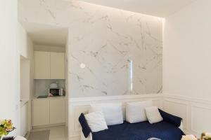 a living room with a blue couch and a marble wall at Relais Mareluna - Luxury Apartments in Salerno