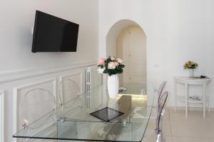 a glass table with a vase with flowers on it at Relais Mareluna - Luxury Apartments in Salerno