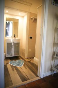- un couloir avec une salle de bains pourvue d'un lavabo et d'un miroir dans l'établissement Bianca Suite B&B, à Salerne