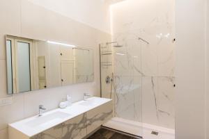 a white bathroom with a sink and a shower at Relais Mareluna - Luxury Apartments in Salerno