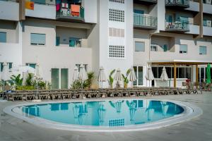 a swimming pool in front of a building at Flor Da Rocha in Portimão