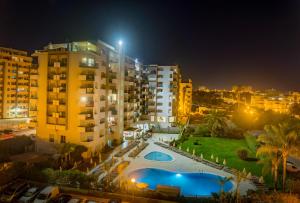 a view of a building at night with a swimming pool at Flor Da Rocha in Portimão
