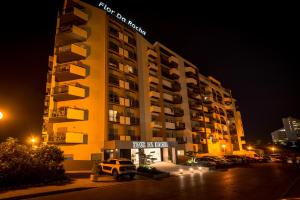 a hotel building with a jeep parked in front of it at Flor Da Rocha in Portimão