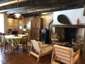a kitchen with a table and chairs and a fireplace at Gite Les Hortalis in Monjoi