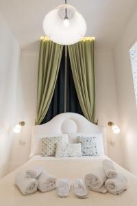 a bedroom with a white bed with a chandelier at Relais Mareluna - Luxury Apartments in Salerno
