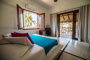 a bedroom with a bed and a couch and a window at Pousada Vayú in Icaraí +135 photos