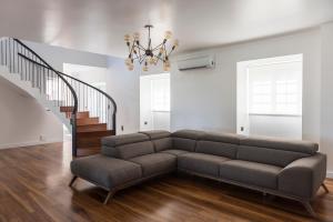 a living room with a couch and a staircase at Volcanic Charming House in Ribeira Grande