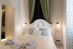 a bedroom with a white bed with towels on it at Relais Mareluna - Luxury Apartments in Salerno