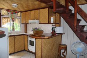 uma pequena cozinha com um lavatório e um fogão em Fare Edith Moorea em Haapiti