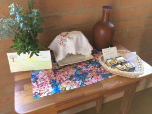 a table with a vase and a table with cookies on it at Oficina da Passagem in São Bento do Sapucaí
