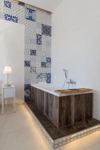 a bathroom with a wooden tub and blue and white tiles at Relais Mareluna - Luxury Apartments in Salerno