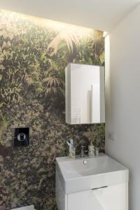 a bathroom with a sink and a wall mural at Relais Mareluna - Luxury Apartments in Salerno