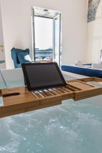 un computer portatile seduto su un tavolo di legno sull'acqua di Relais Mareluna - Luxury Apartments a Salerno