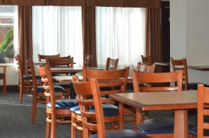 a dining room with tables and chairs and windows at Home Inn & Suites in Montgomery