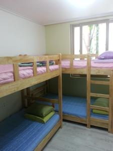 מיטה או מיטות קומותיים בחדר ב-Kangguan Guesthouse