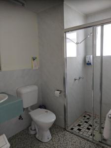a bathroom with a toilet and a glass shower at Best One Motel in Rockhampton