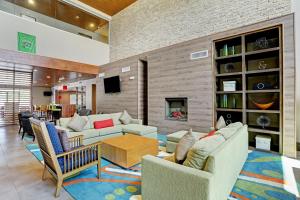 a living room with couches and a fireplace at Country Inn & Suites by Radisson Houston Westchase-Westheimer in Houston
