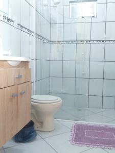 y baño con aseo, lavabo y ducha. en Apartamentos C. Santos, en Penha