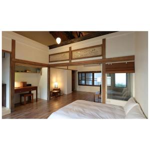 台南的住宿－青田居，卧室配有白色的床和书桌