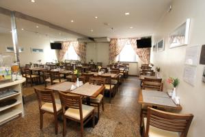 a restaurant with wooden tables and chairs and windows at Mengo Palace Hotel in Rio de Janeiro