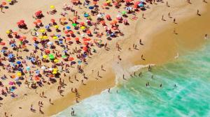 a crowd of people on a beach with umbrellas at Mengo Palace Hotel in Rio de Janeiro