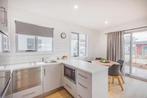 a kitchen with white counters and a table and chairs at Tasman Holiday Parks - St Helens in St Helens