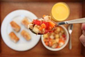 a person holding a spoon with food on it at Mengo Palace Hotel in Rio de Janeiro