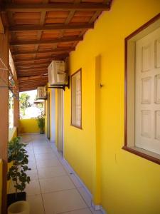 un pasillo de un edificio con una pared amarilla en Pousada Aritibe en Ilha de Boipeba