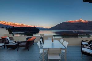 a patio with a view of a lake and mountains at 21 Lakefront by Amazing Accom in Queenstown