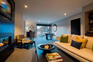 a living room with a couch and a fireplace at 21 Lakefront by Amazing Accom in Queenstown