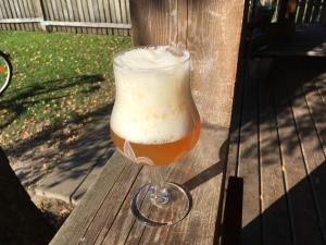 Ein Glas Bier steht auf einer Holzbank in der Unterkunft Vila Migla in Pašekščiai