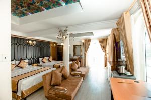 een hotelkamer met 2 bedden en een bank bij HaLong Starlight Inn & Travel in Ha Long