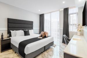 a bedroom with a large bed with a black headboard at Gladius Hotel & Suites-Parramatta Marsden Street in Sydney +20 photos