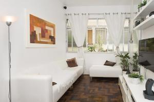 una sala de estar blanca con muebles y ventanas blancos. en Fabi´s Home - Copacabana, en Río de Janeiro