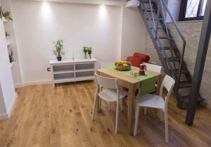 una sala da pranzo con tavolo, sedie e scala di Manganelli Home a Catania