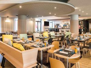 a restaurant with tables and chairs and a bar at Novotel Nice Centre Vieux Nice in Nice