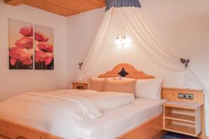 a bedroom with a white bed with a canopy at Alpin Apart Maurer in Längenfeld