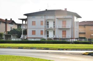 uma grande casa branca na beira de uma estrada em Villa Giulia em Bonate Sotto