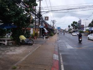a person riding a motorcycle down a city street at Aquaman @chalong pier in Chalong