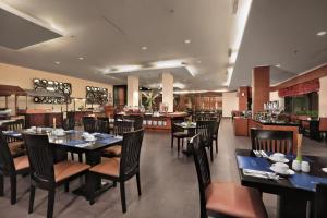 TanjungにあるASTON Tanjung City Hotelのレストラン内のダイニングルーム(テーブル、椅子付)