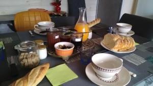 a table topped with plates of food and bread at Les Chambres du Faubourg in Montrichard