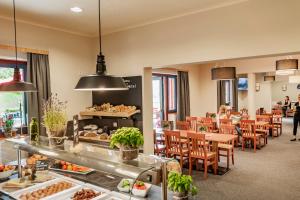restauracja ze stołami i krzesłami oraz bufetem w obiekcie JUFA Hotel Maria Lankowitz w mieście Maria Lankowitz